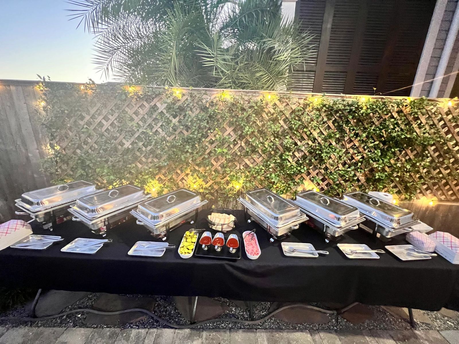 A catering buffet line of chafing dishes set up outdoors