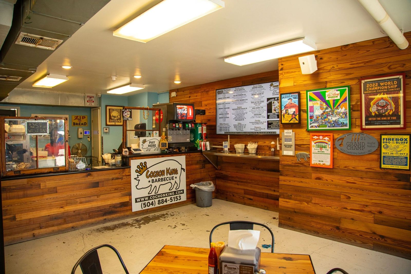 The order counter, menu screens and wood-paneled walls inside the restaurant